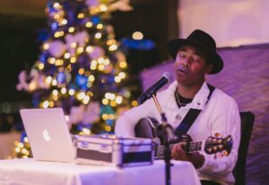 live musician in front of christmas tree